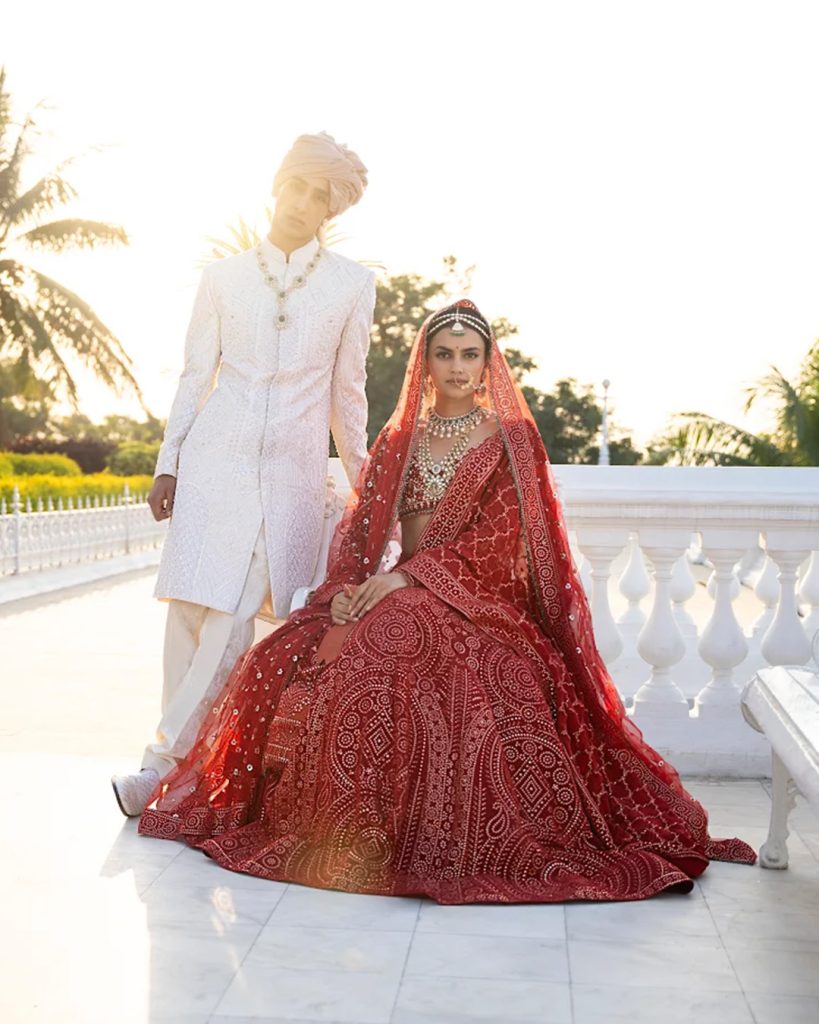 red and ivory sherwani and lehenga