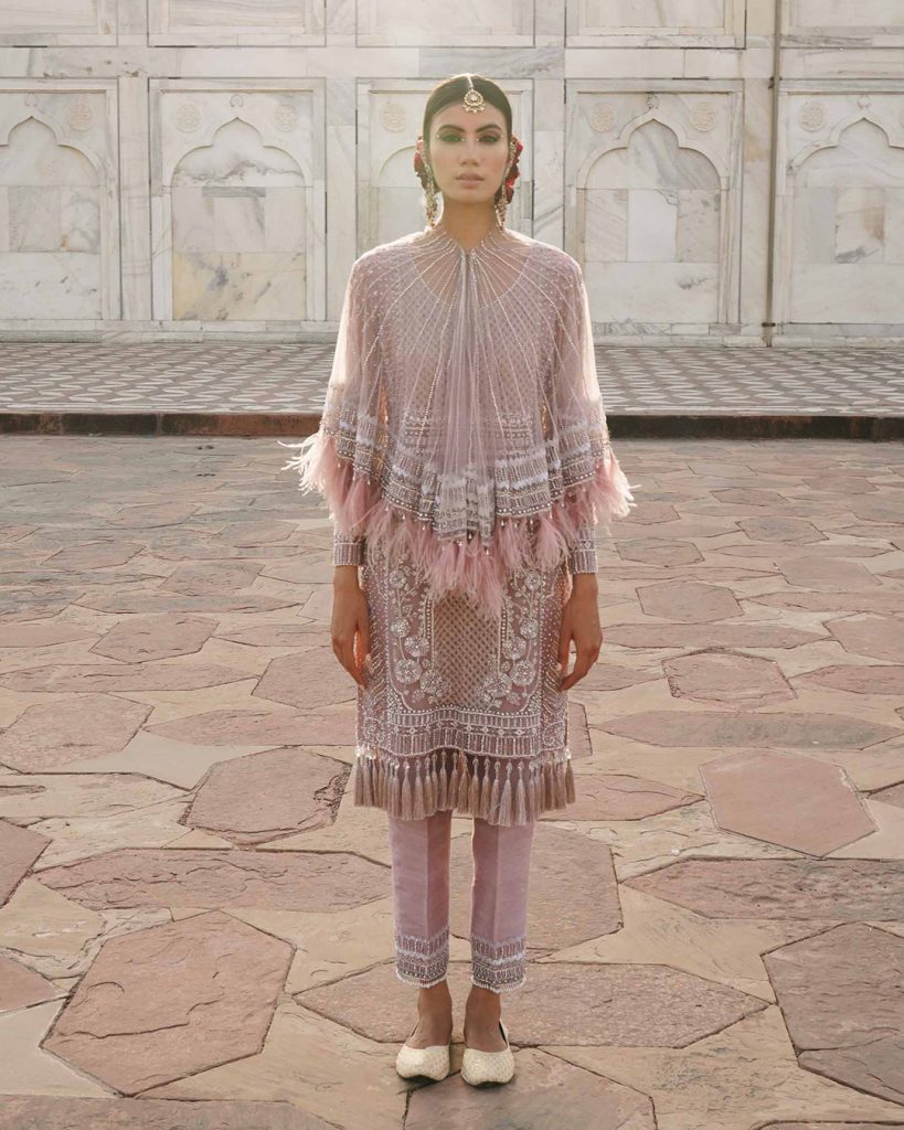 Model in a pastel pink short embellished kurti paired with matching sleek cigarette pants